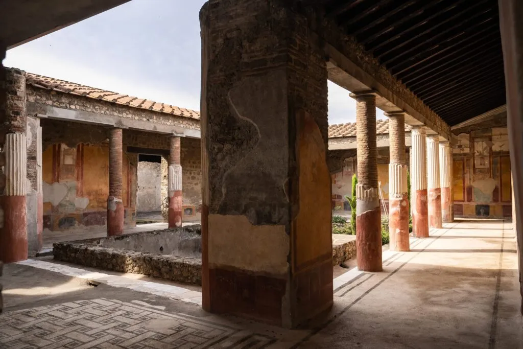 perystyl rzymskiego domu z kolumnami i freskami w Pompejach