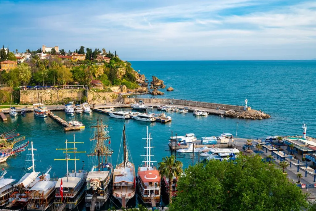 stary port w Antalyi pod murami starego miasta Kaleiçi, łodzie wycieczkowe na turkusowej wodzie