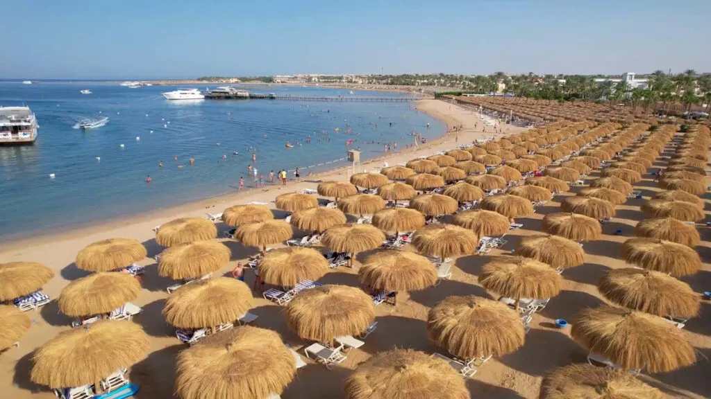 linia brzegowa z hotelowymi parasolami z trzciny w hotelu Xanadu Makadi Bay w Hurgadzie